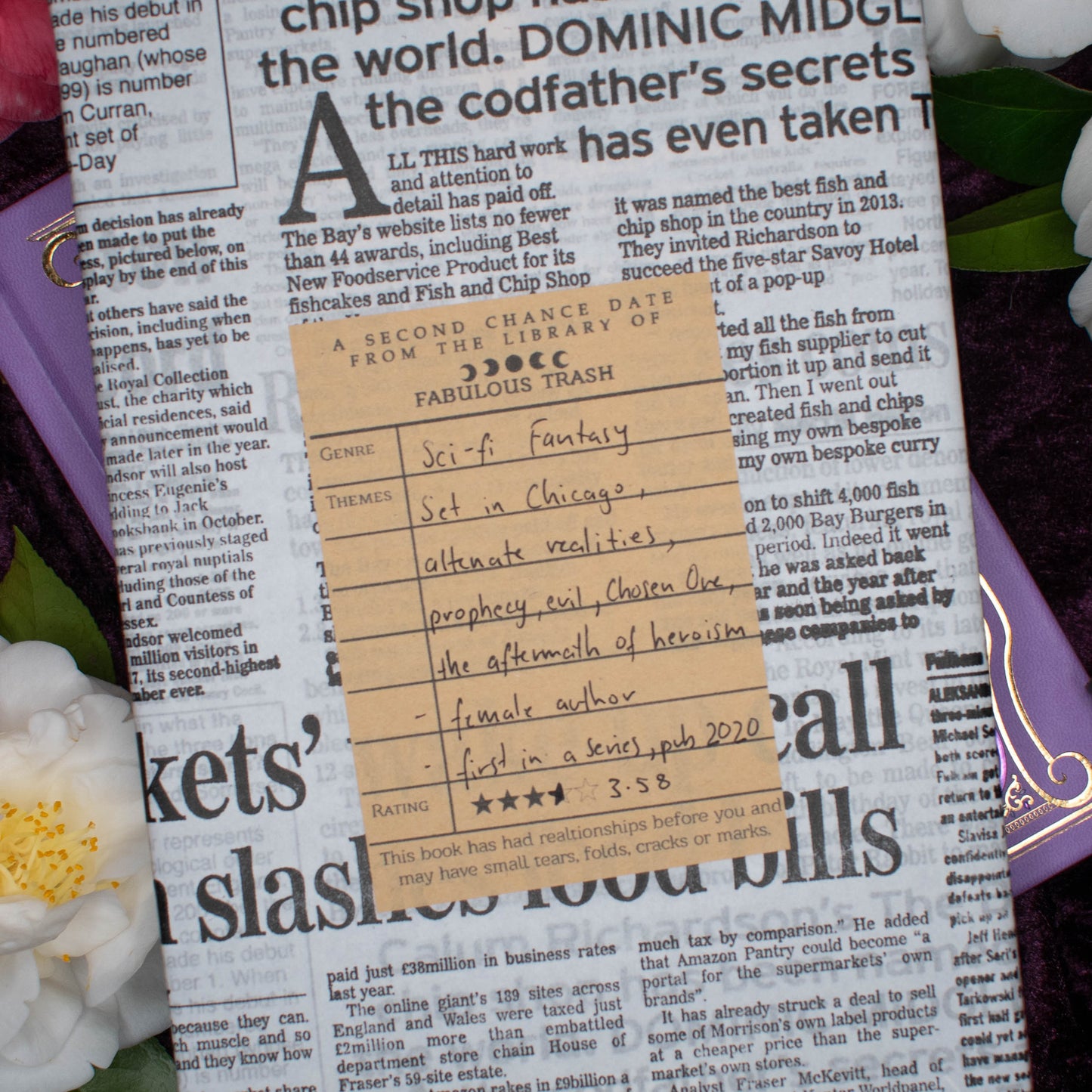 Book with a library card on top of it, surrounded by flowers
